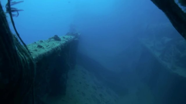 Shipwreck underwater in Red Sea Egypt. Ghost ship background of fish in the blue lagoon on coral reef. Extreme tourism.Deep diving.