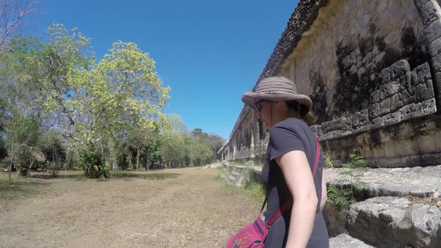 A gimbal shot of a woman tourist walking in Ek Balam Mayan Ruins