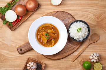 spicy chicken and rice on wooden background