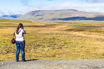 Naklejka na ściany i meble the tourist photographs a landscape in Iceland