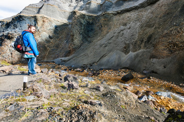 tourist near stream in gorge in Landmannalaugar