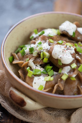 Close-up of boiled rye dumplings stuffed with sauerkraut and served with sour cream, selective focus, shallow depth of field