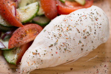 Close-up of boiled chicken breast fillet with vegetable salad, selective focus