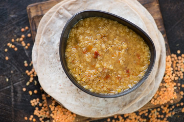 Above view of red lentils indian soup with chapati flatbread, horizontal shot