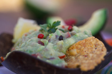 Bowl of frewsh guacamole with tortilla chips. Healthy vegetarian food.