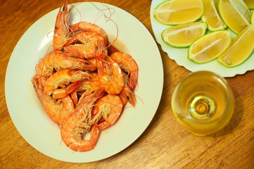 many cooked orange king shrimps with lemons