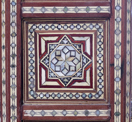 Closeup of arabesque seamless pattern on an ancient old wooden tea table