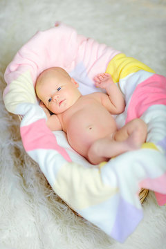 beautiful newborn baby lies on a soft blanket in the crib