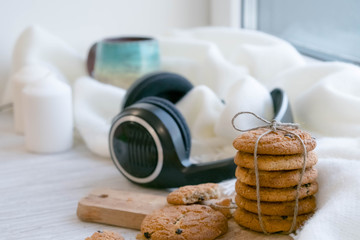 cozy winter still life: warm woolen knitting, hot tea, red book, Christmas cookies and music. Headphones. Hygge style. Cozy winter home morning holiday. Soft photo