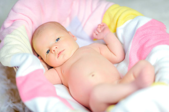 beautiful newborn baby lies on a soft blanket in the crib