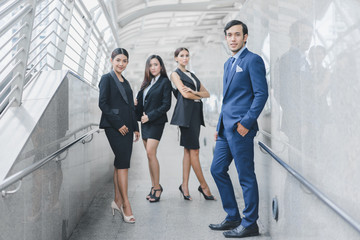 Professional business team looking forward confidently standing outdoors in cityscape background