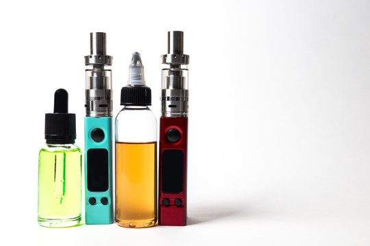 e- liquid, e-juice in the bottles and e-cigarette (vape)  isolated on the white background with copyspace