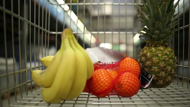 Time laspse of trolley with fruits rushing through supermarket