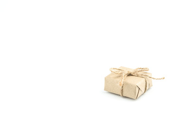 Vintage brown craft paper gift box tied with brown rope bow ribbon isolated on white background for Christmas, New Year and Valentine Day present.