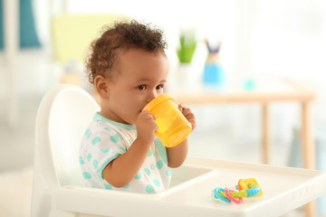 Cute baby drinking water indoors - Powered by Adobe