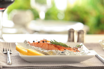 Plate with tasty grilled salmon on table in restaurant