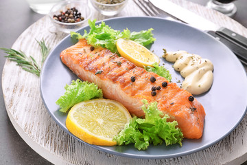 Plate with tasty grilled salmon on table