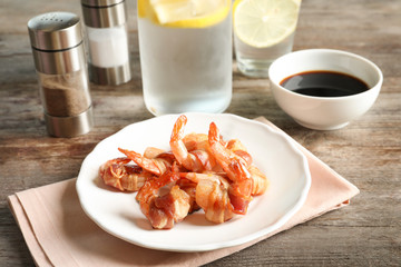 Plate with shrimps wrapped in bacon on table