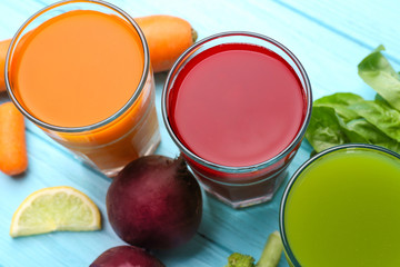 Glasses with various fresh juices and ingredients on table