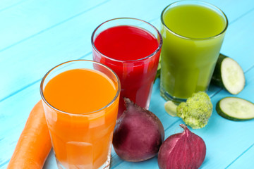 Glasses with various fresh juices and ingredients on table