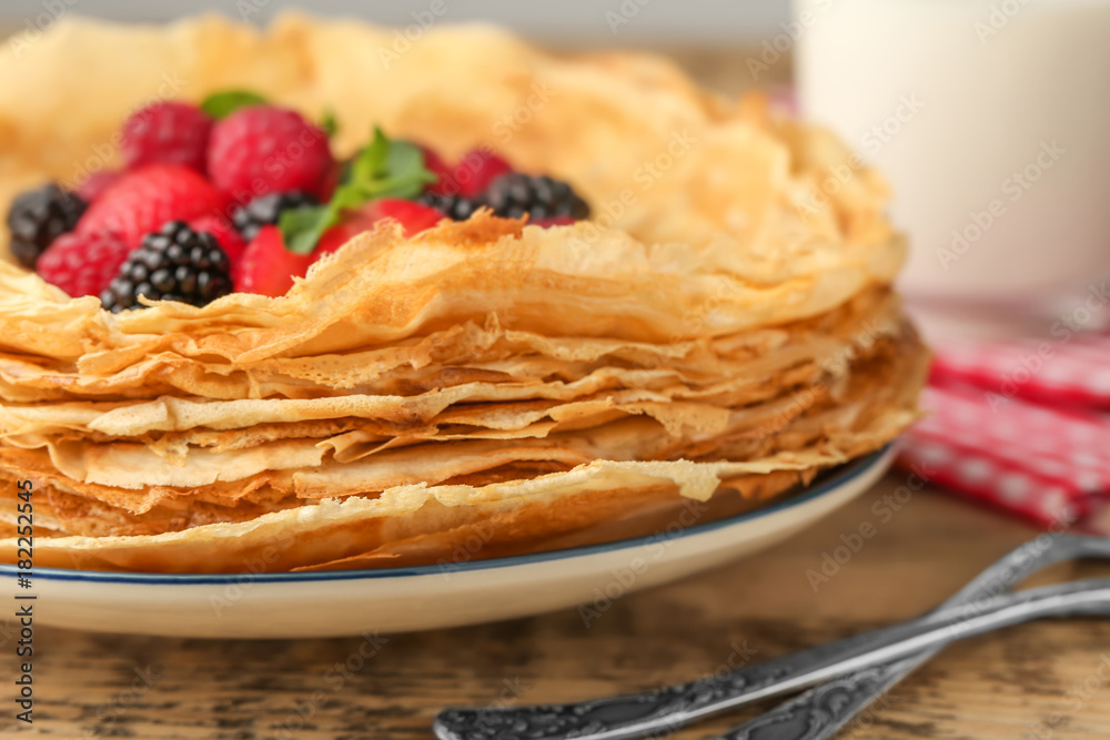 Canvas Prints plate of delicious thin pancakes with berries on wooden table, closeup