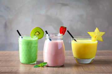 Glassware with different milkshakes on table