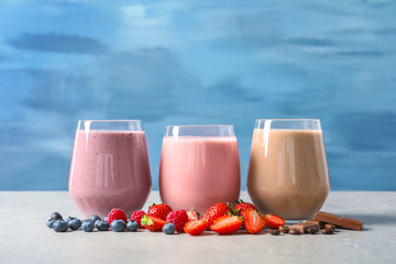 Glasses with different milkshakes on table
