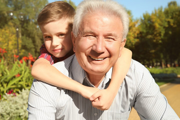 Obraz premium Elderly man with grandson in park
