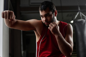 Naklejka na ściany i meble Boxing. Portrait of a boxer on the background of the gym