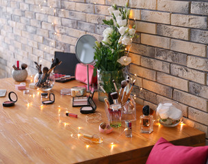 Set of decorative cosmetics and beauty accessories on dressing table indoors