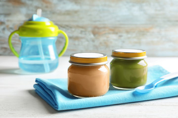 Jars with healthy baby food on wooden table