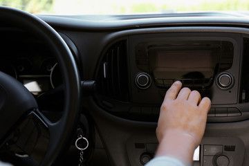 Man tuning radio in car