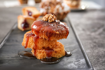 Tasty biscuit dessert with caramel sauce on table