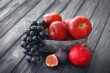 Basket and fresh fruits on wooden table