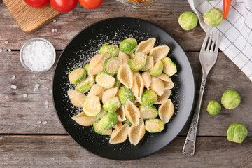 Plate of pasta with Brussels sprouts and cheese on table