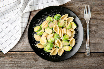 Plate of pasta with Brussels sprouts and cheese on table