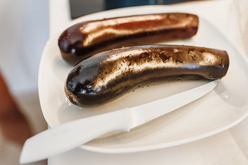eggplant with a knife on a plate in kitchen