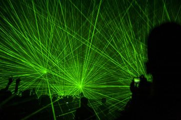 Silhouette of crowded people in light and sound performance concert