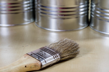 Old paintbrushes for paint, Cans of paint on wooden table. Painting workshop.