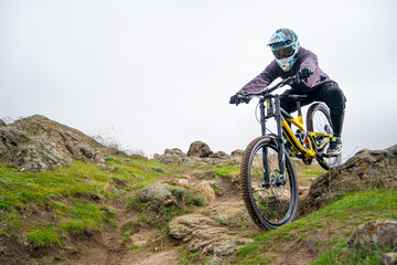 Naklejka na ściany i meble Professional Cyclist Riding Mountain Bike Down the Rocky Hill. Extreme Sport and Enduro Biking Concept.