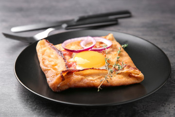Tasty thin buckwheat pancake with egg on plate