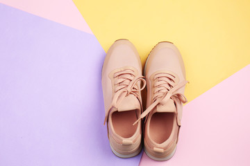 Pair of sport shoes on color background