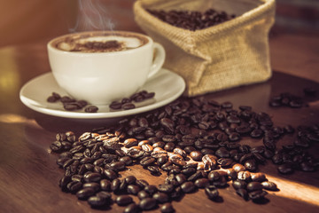 coffee cup and coffee beans on wooden table.