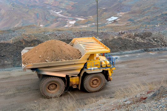 A truck on board a quarry carries a load.