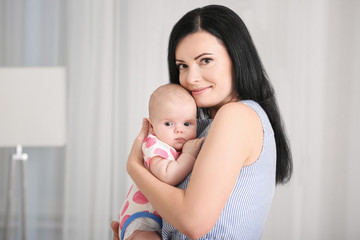 Young mother and cute baby at home