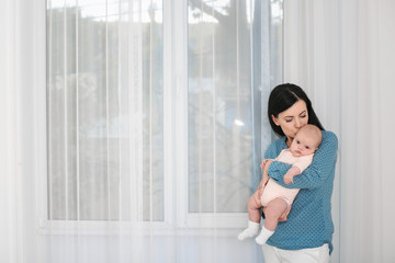 Young mother and cute baby at home