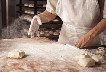 Fotobehang Man preparing buns in bakery © Africa Studio
