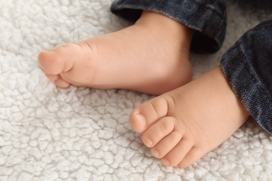 Baby feet on light plaid, closeup