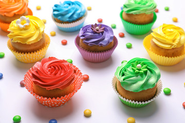Tasty colorful cupcakes on white background