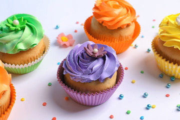 Tasty colorful cupcakes on white background